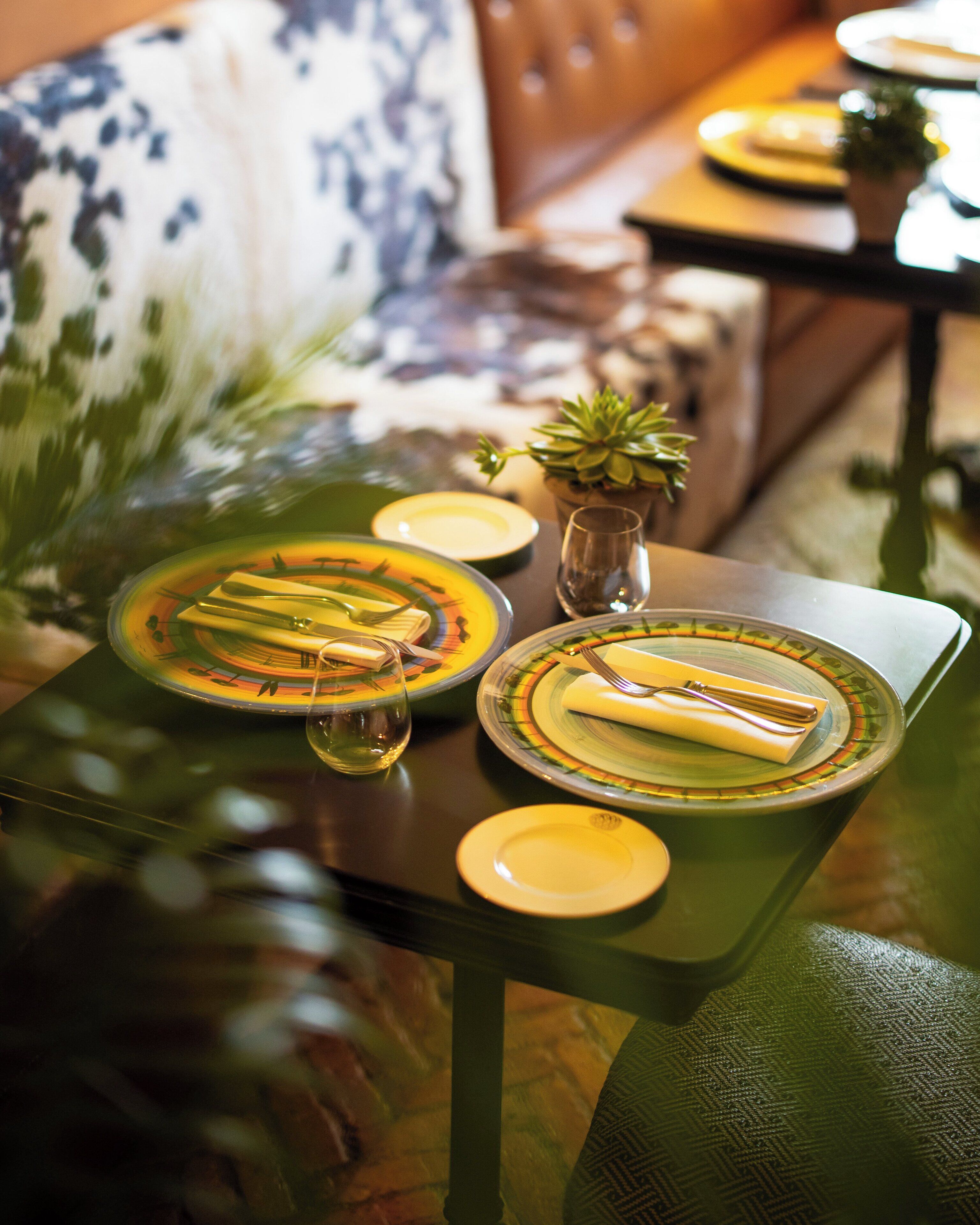 A dining table set with plates, cutlery, and a glass of water.