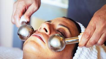 A person receiving a facial treatment with metal tools.