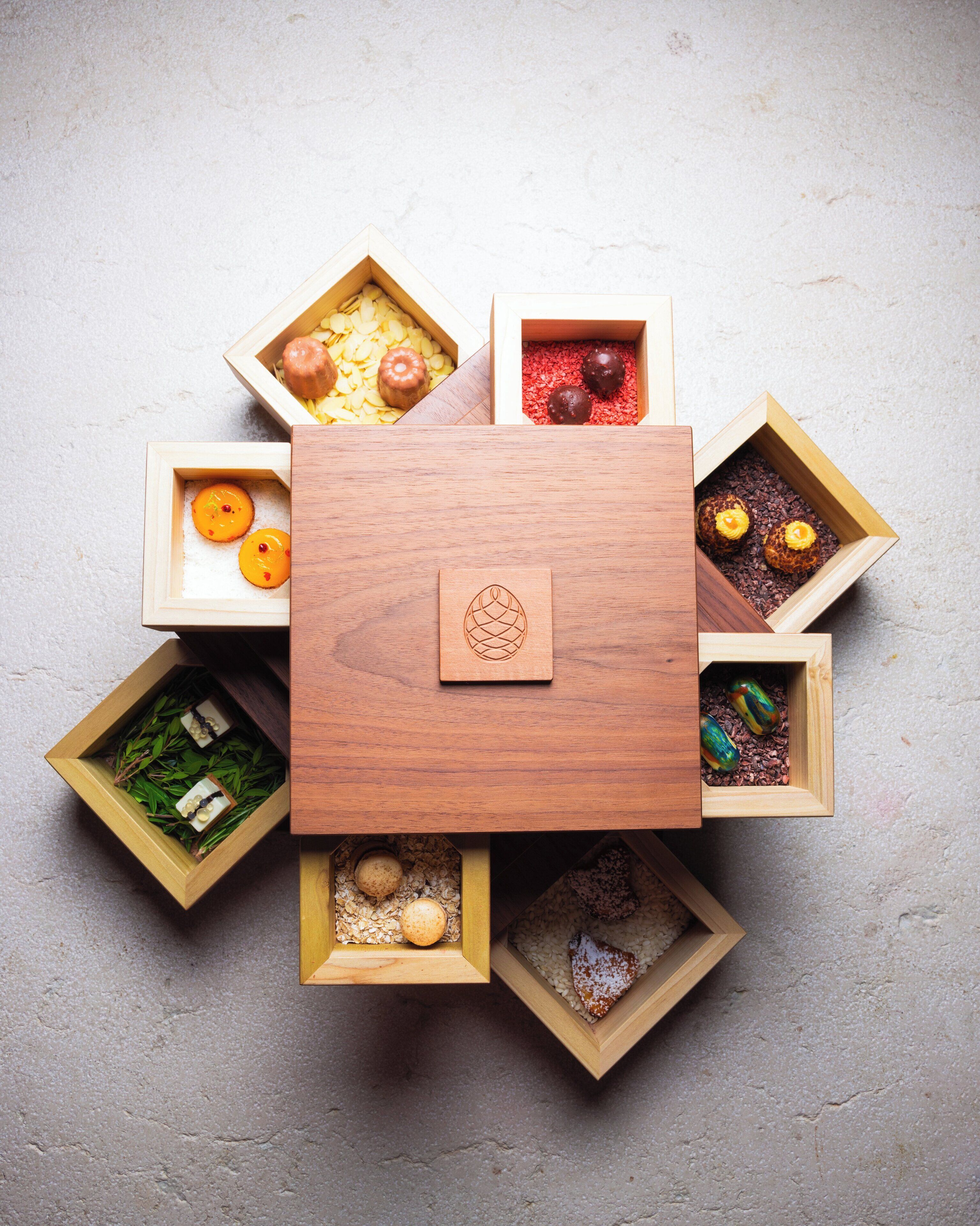 Une table en bois dotée de plusieurs compartiments contenant divers aliments.