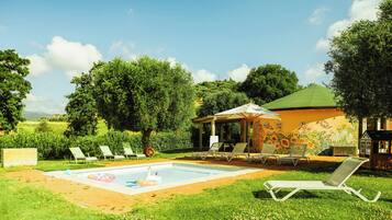 Area piscina con sedie a sdraio, una piccola piscina e un gazebo con un affresco.