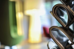 A close-up of a mirror with a heart-shaped frame, reflecting a blurred interior space.