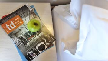 Een tijdschrift op een bed, met een groene appel erbovenop.