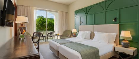 Une chambre d’hôtel avec un grand lit, deux tables de chevet, un bureau, une chaise et un téléviseur.