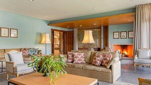 A spacious living room with a sofa set, a coffee table, and a fireplace.