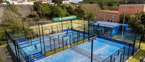 Una piscina interior con varias pistas, rodeada por una valla, y un cartel que dice 'Acores Fusion Club'.