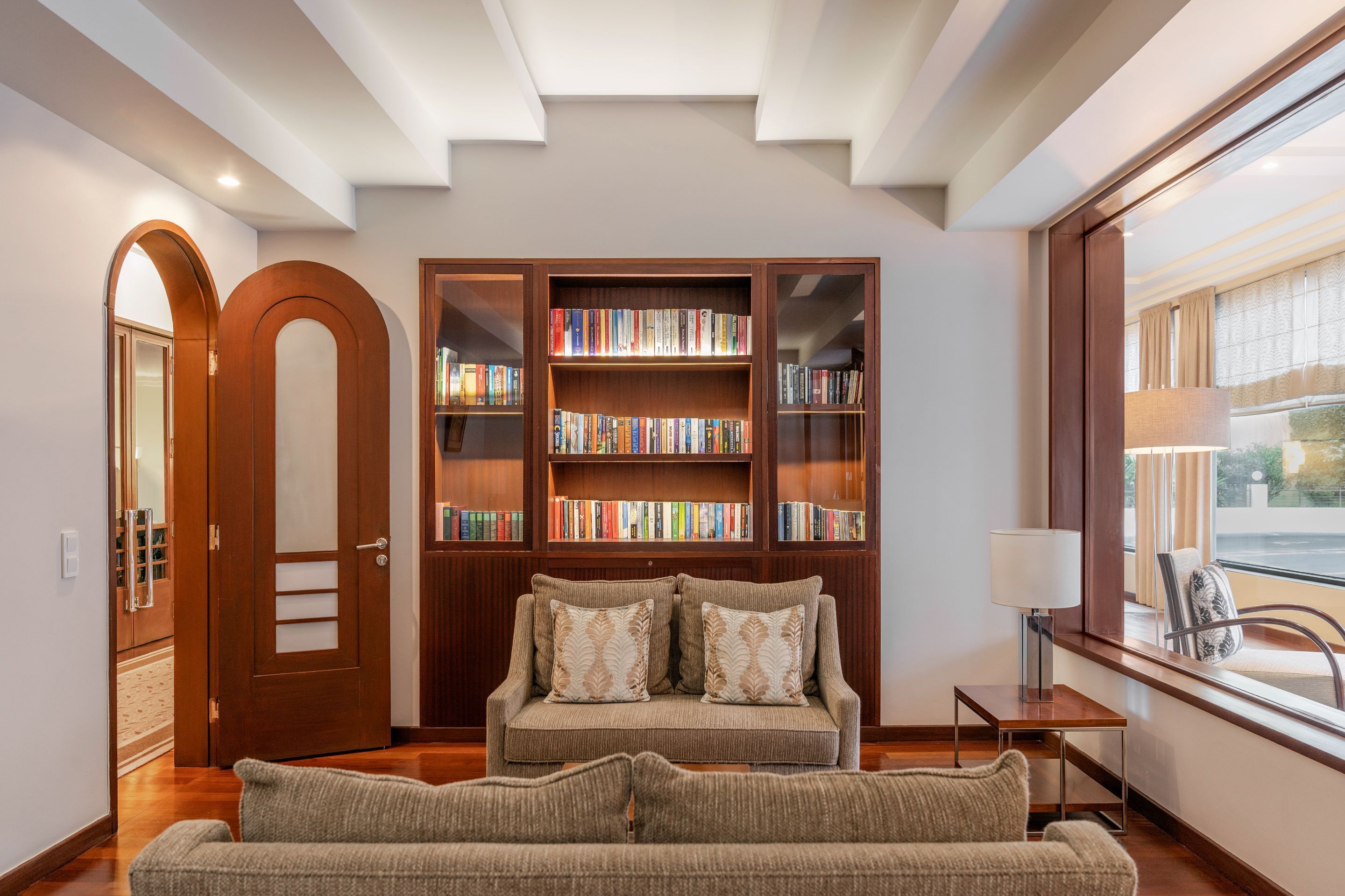 A cozy reading area with a sofa, a bookshelf, and a window with a view.