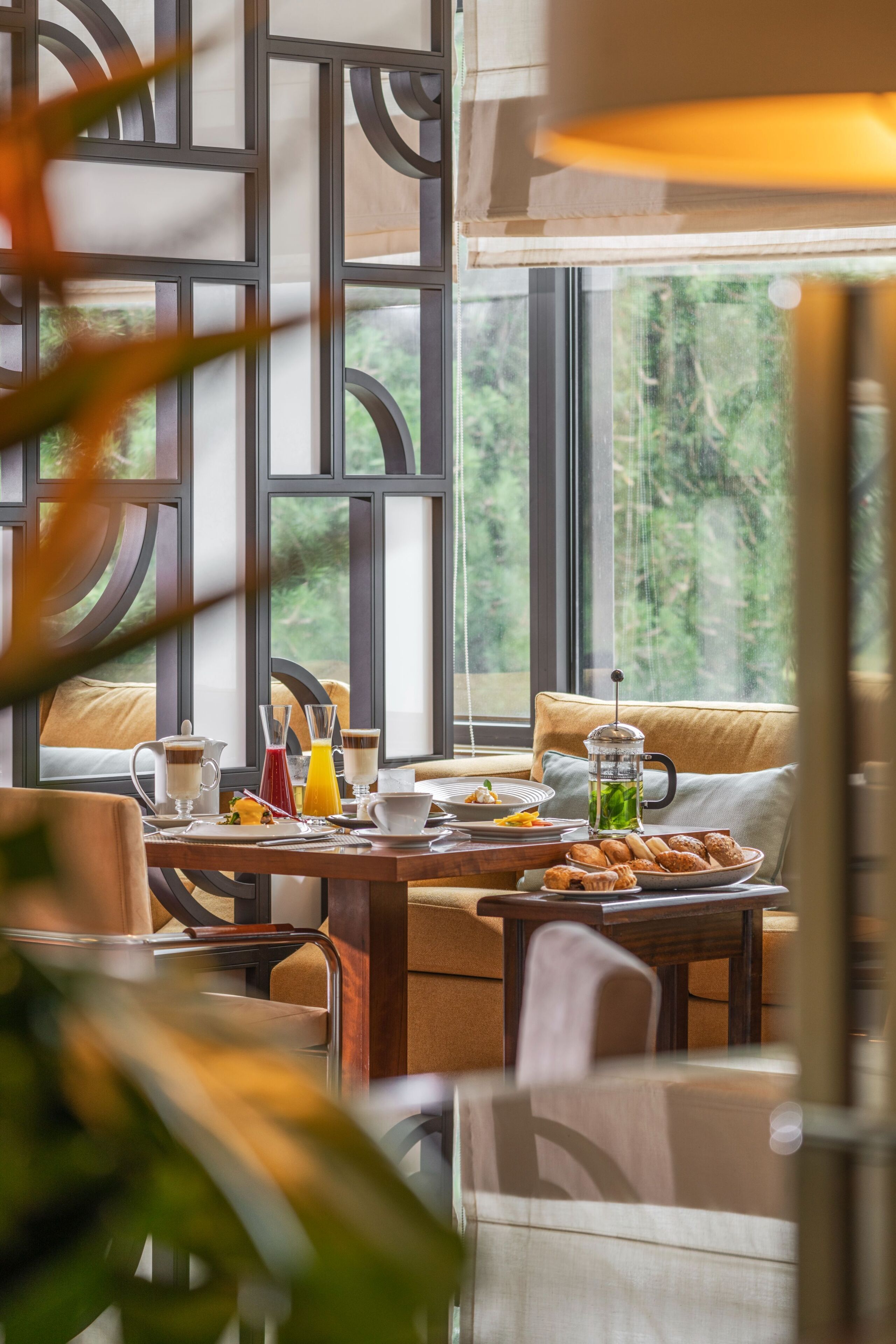 A dining area with a table set for breakfast, including plates, glasses, and a pitcher.
