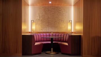 A corner seating area with a round table and two wall-mounted lamps.