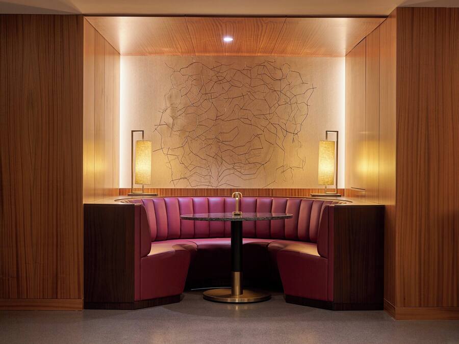 A corner seating area with a round table and two wall-mounted lamps.