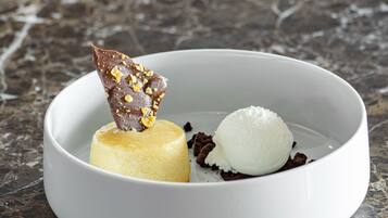 A dessert in a white bowl on a marble surface.