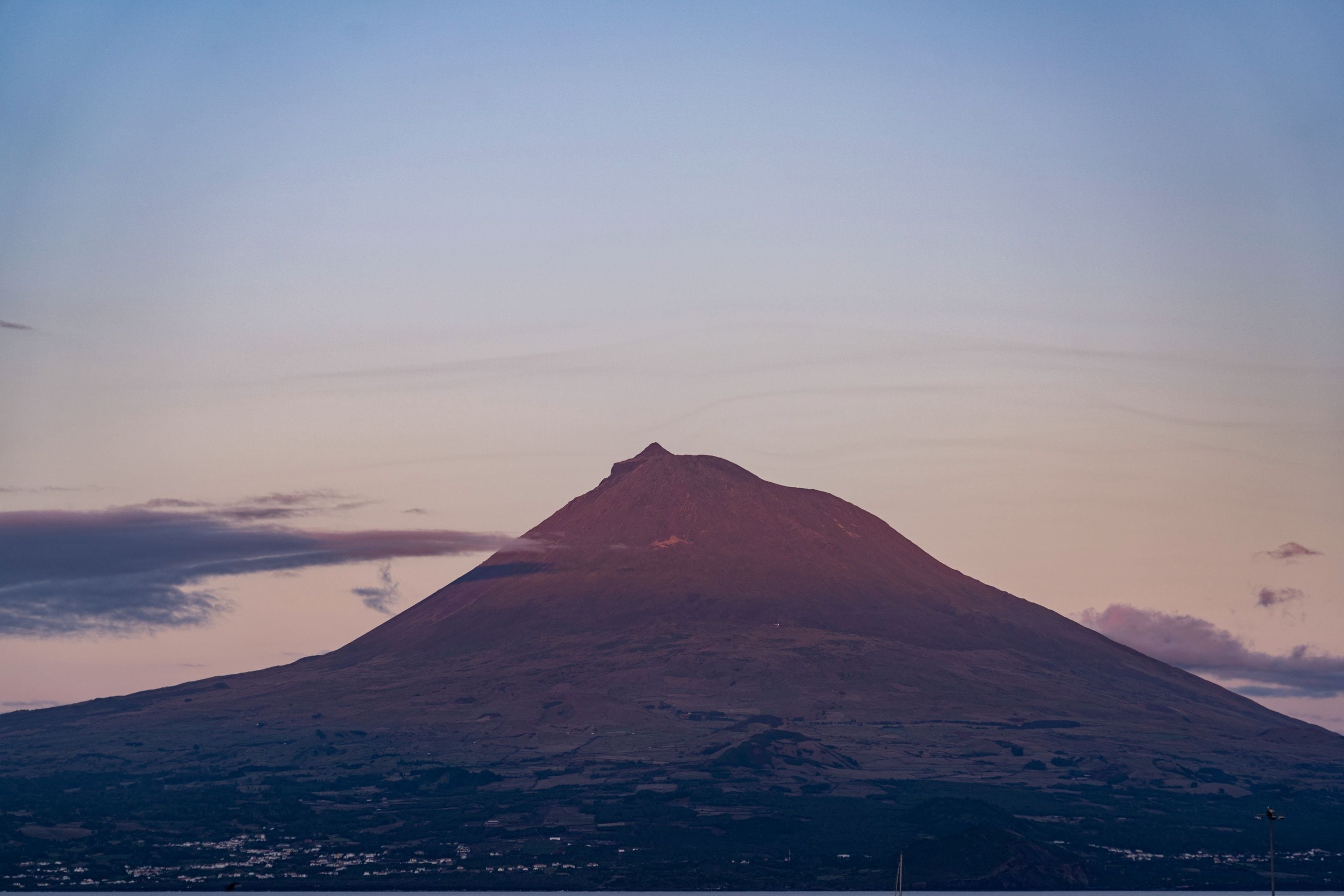 Una montaña con un pico, rodeada de un paisaje.