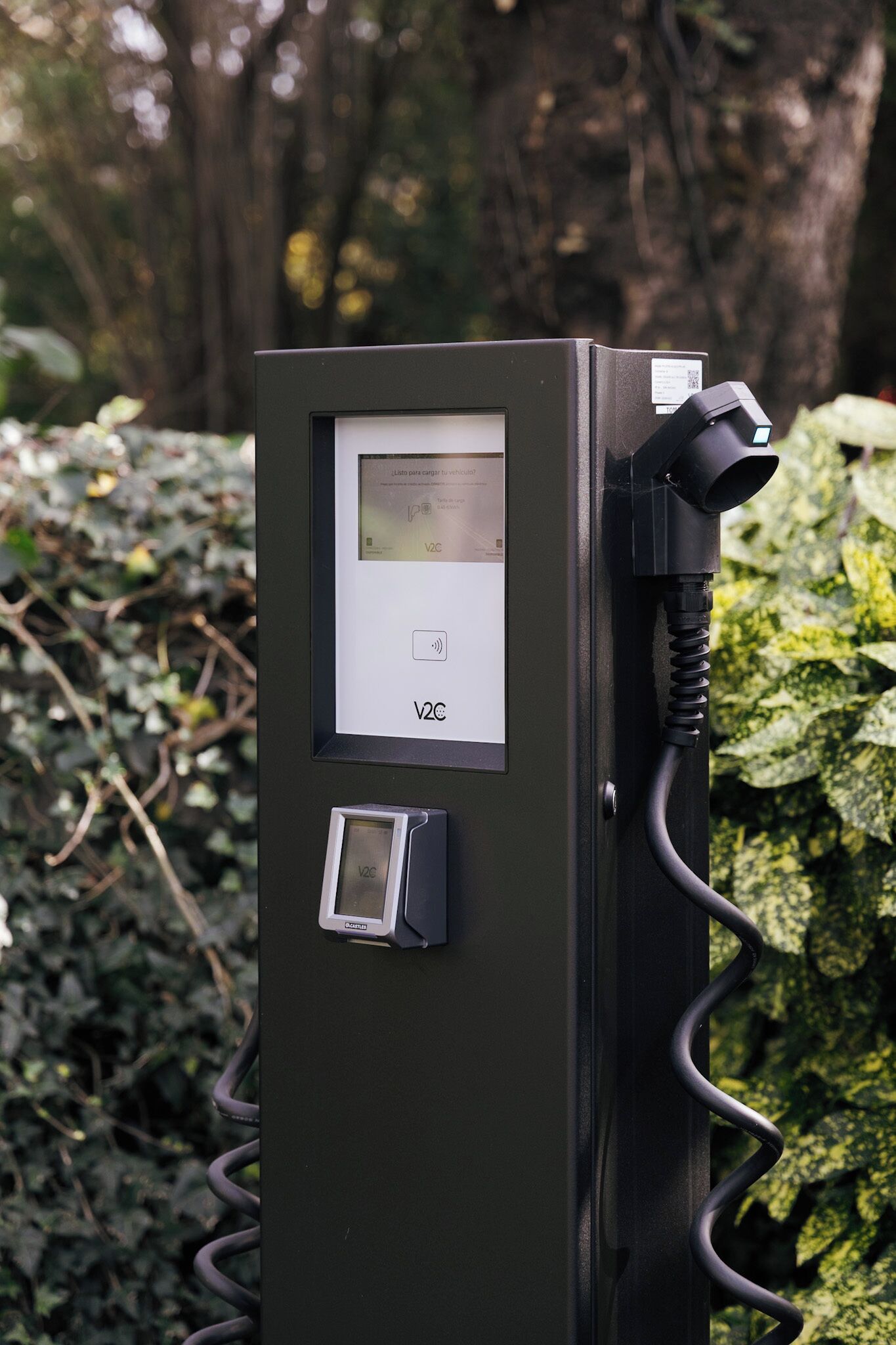 A V2C charging station with a digital display, a charging cable, and a compact device.