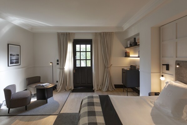 A hotel room with a bed, a desk, a chair, and a wardrobe. - Villa Soro (San Sebastián)