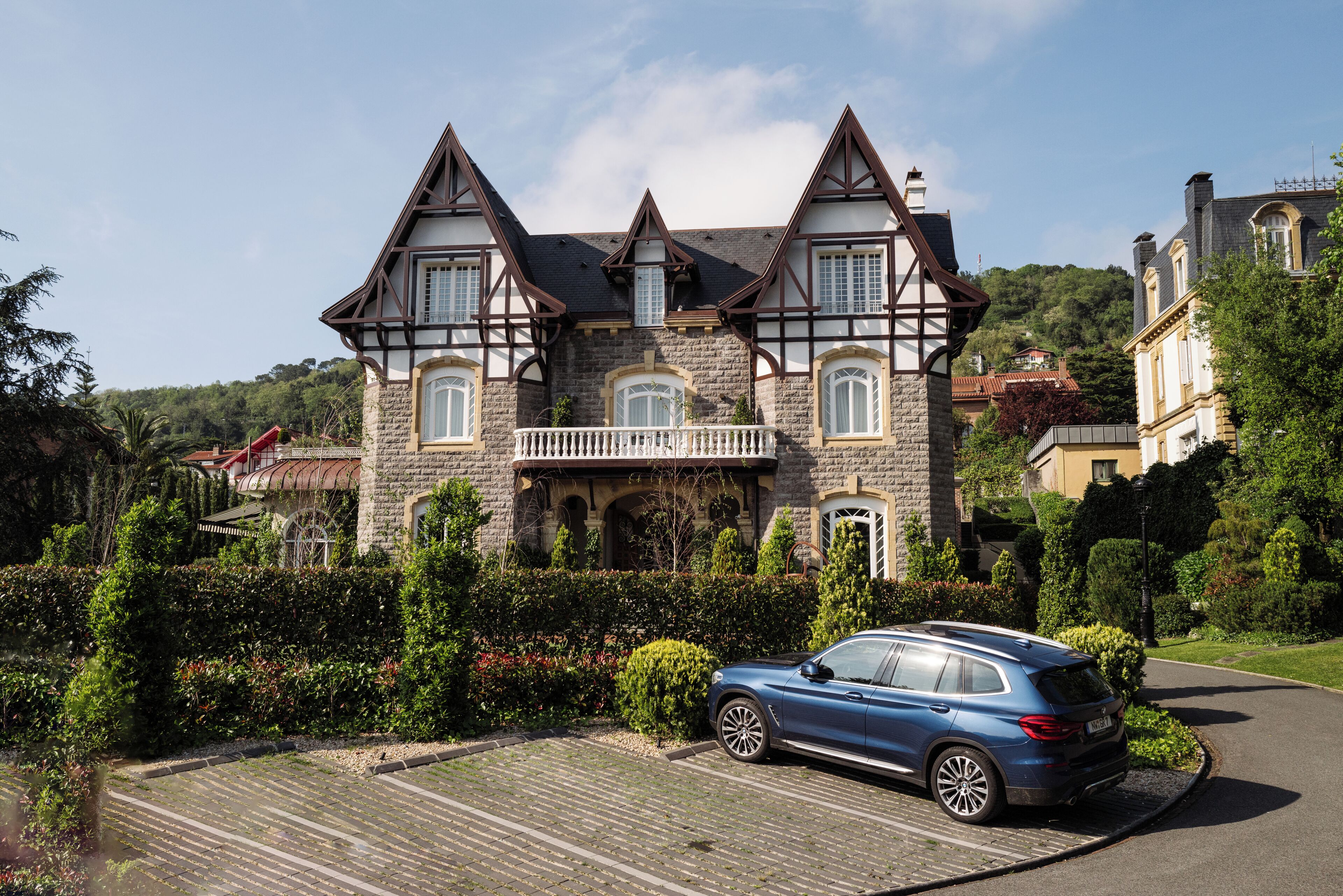 Una casa grande e histórica con fachada de piedra, múltiples ventanas y un balcón.
