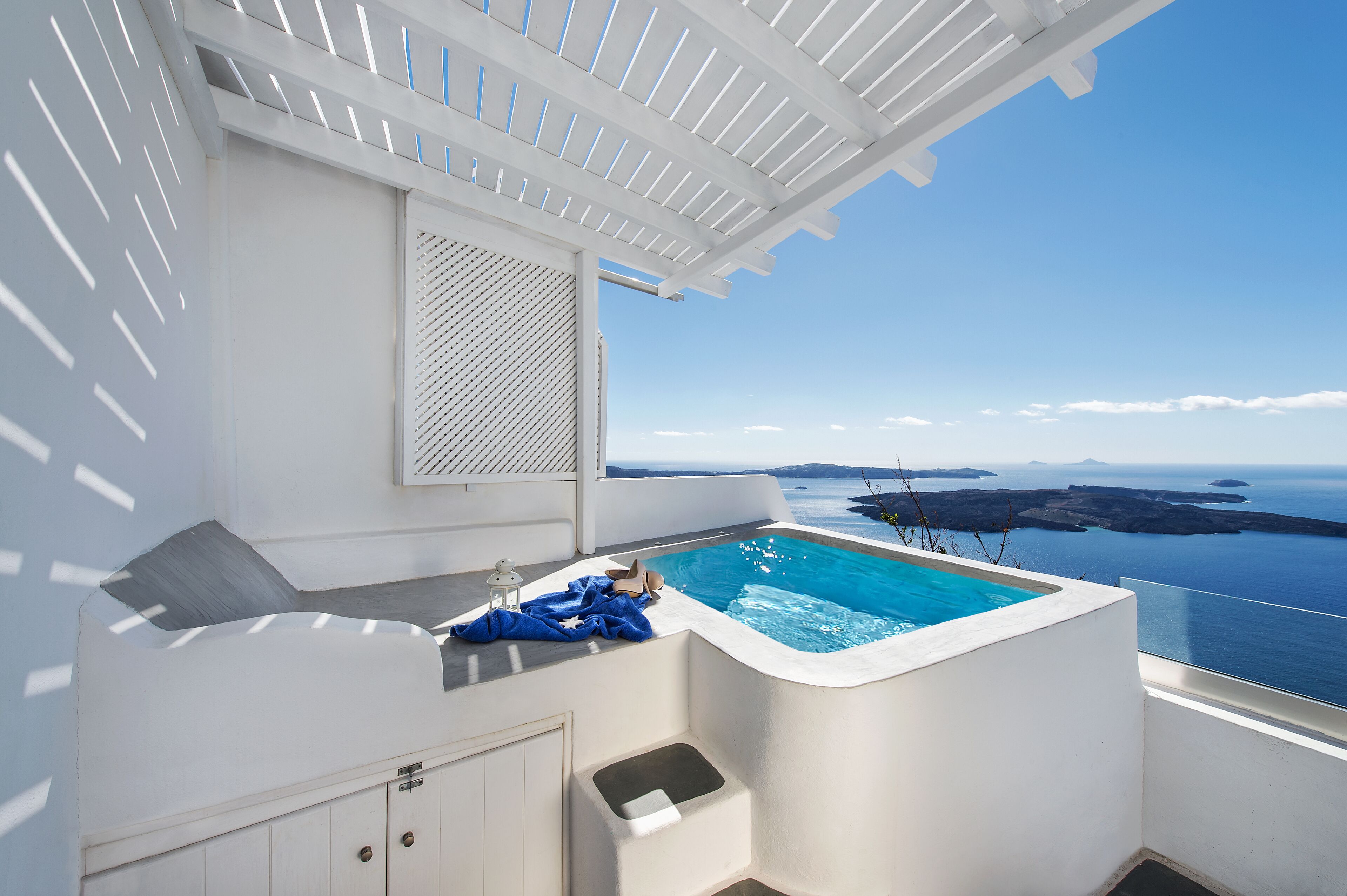 Ein moderner Poolbereich im Freien mit freiem Blick auf das Meer und die in der Ferne liegenden Inseln.
