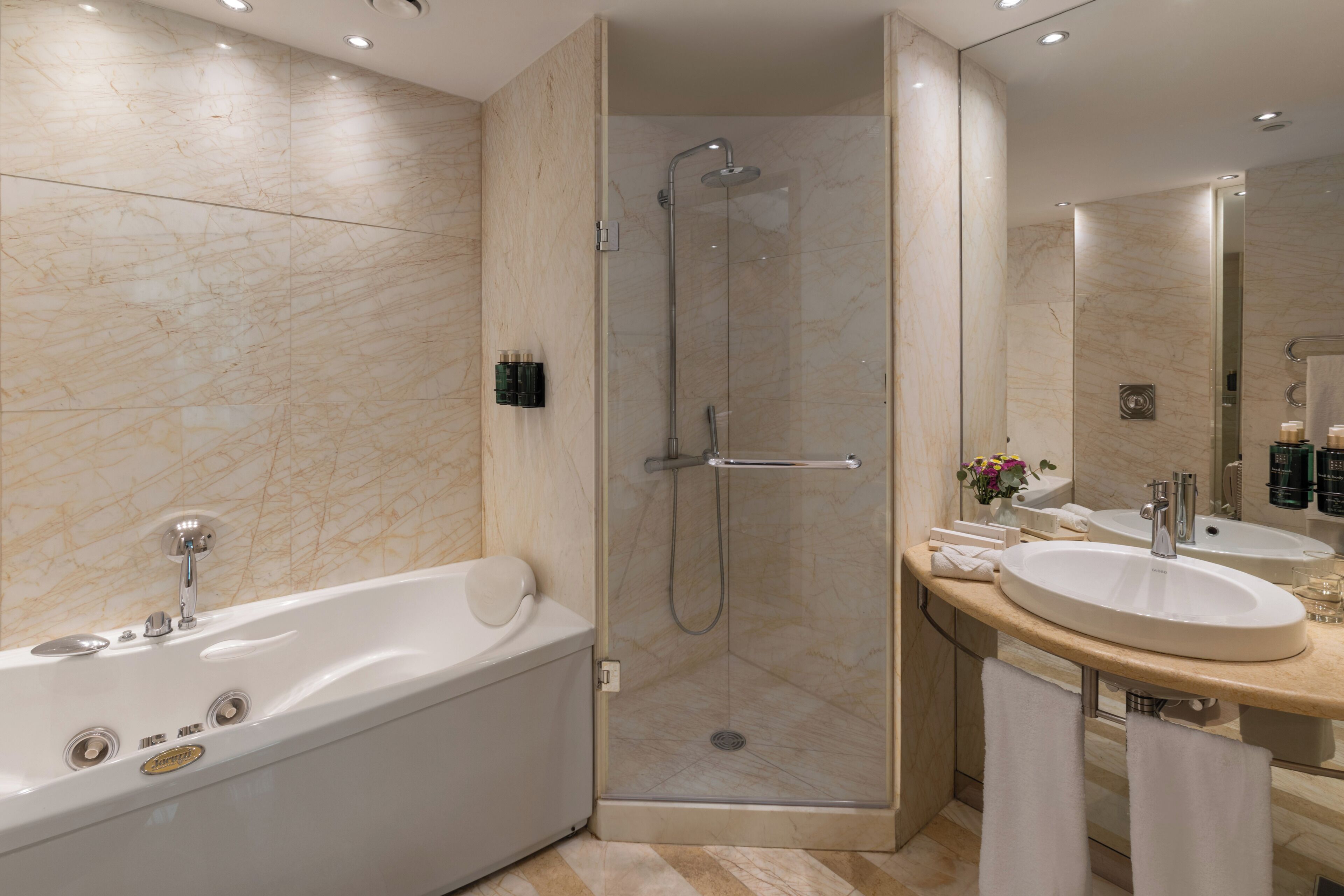 Een moderne badkamer met een badkuip, een douche met glazen wanden en een wastafelmeubel met een wastafel en spiegel.