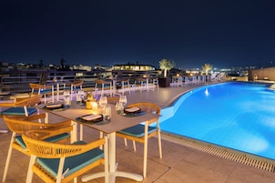 Una piscina al aire libre de temporada, sombrillas