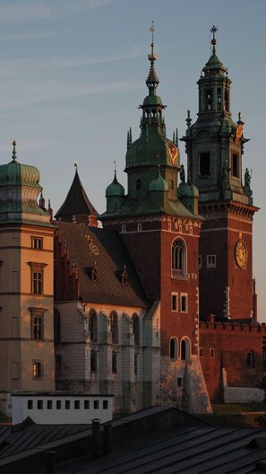 A historic building with multiple towers and domes, featuring a prominent clock tower and a large central dome. - Hotel Copernicus (Kraków)