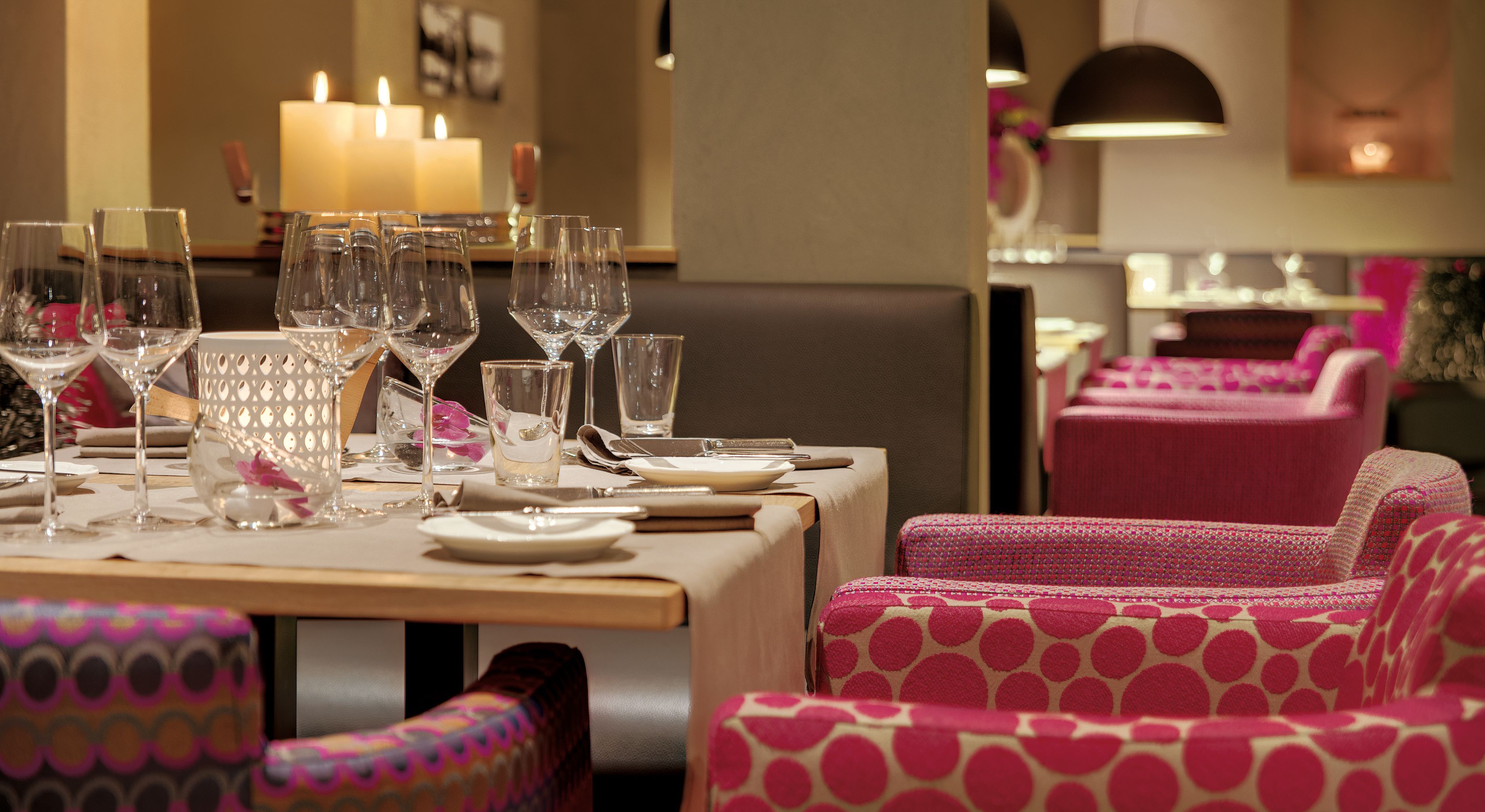 A restaurant with a table set for dining, featuring clear glassware and plates.