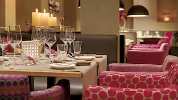 A restaurant with a table set for dining, featuring clear glassware and plates.