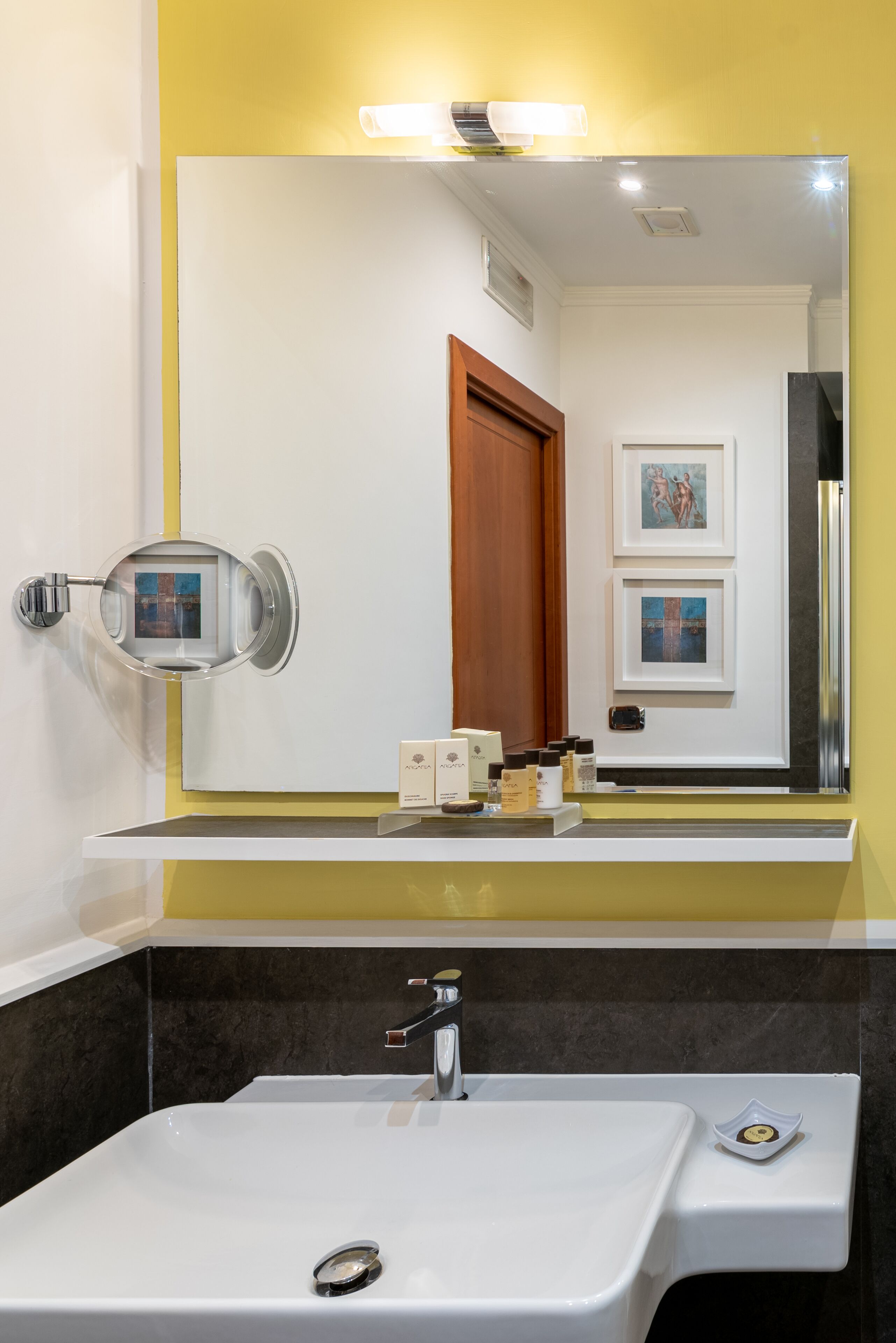 A bathroom with a white sink, a mirror, and a vanity with toiletries.