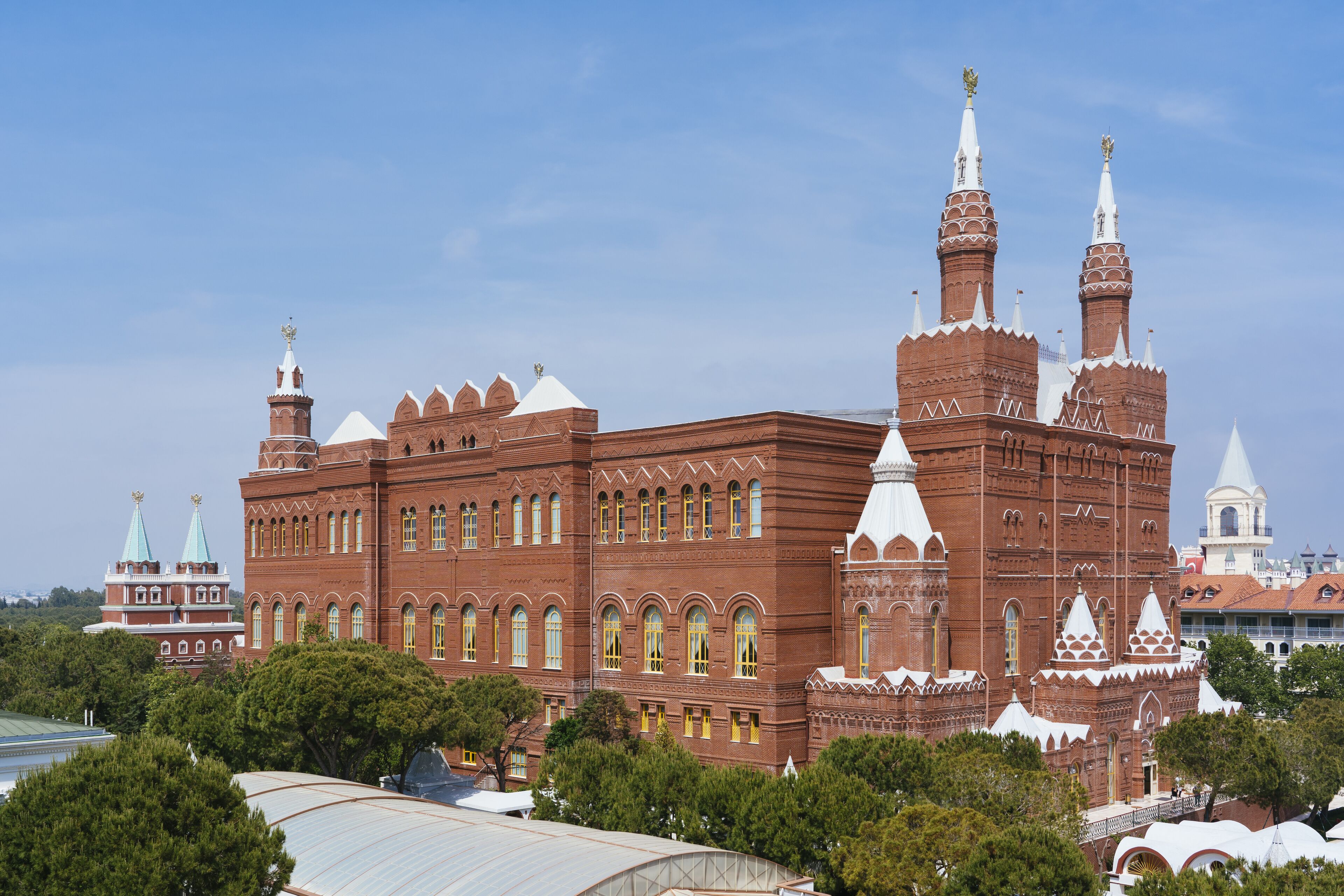 Un edificio grande y de estilo histórico con múltiples torres y cúpulas, rodeado de árboles y otros edificios.