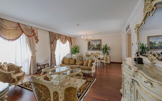 Una lujosa sala de estar con muebles ornamentados, un candelabro y un espejo grande.
