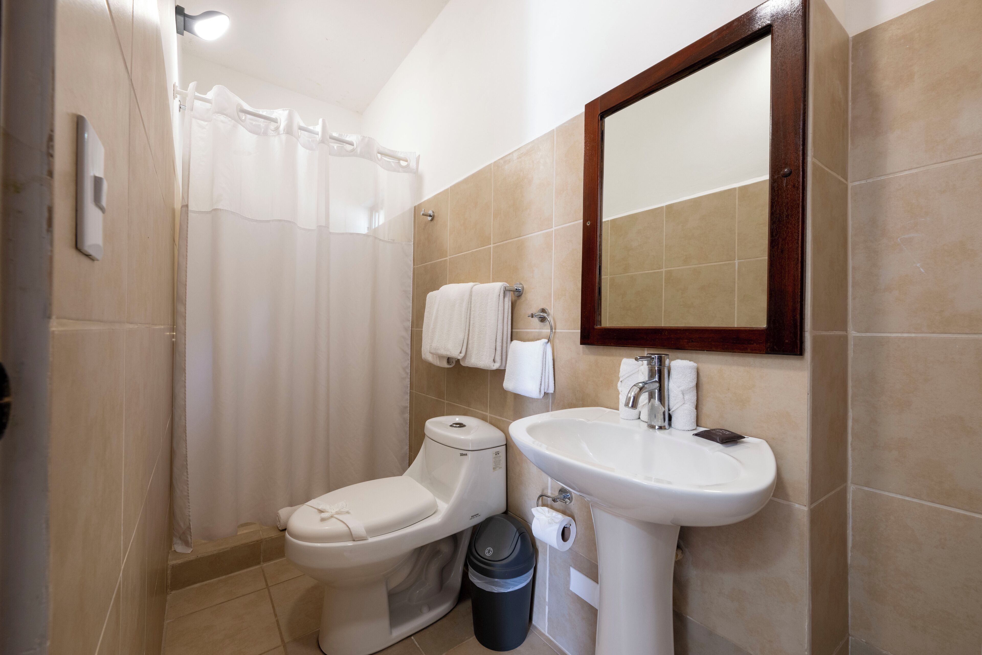 A bathroom with a toilet, sink, and shower curtain.
