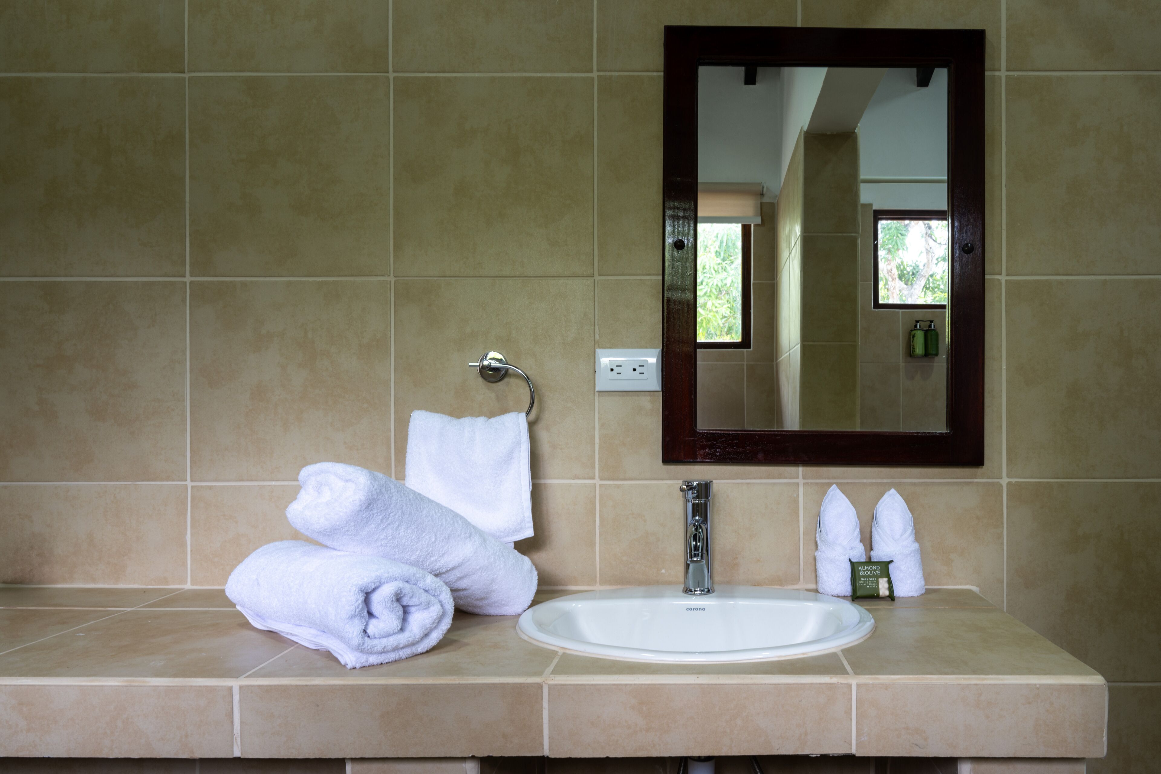 Ein Badezimmer mit Waschbecken, Spiegel und zwei Handtüchern auf der Ablagefläche.