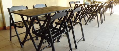 Une cafétéria avec de nombreuses tables et chaises disposées en rangées.