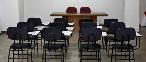 A conference room with a long table and multiple chairs.