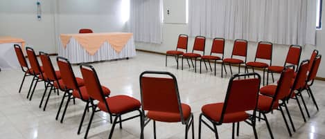 Egy tárgyaló, amelyben egy asztal és székek vannak, és ezeket egy megbeszéléshez rendezték.