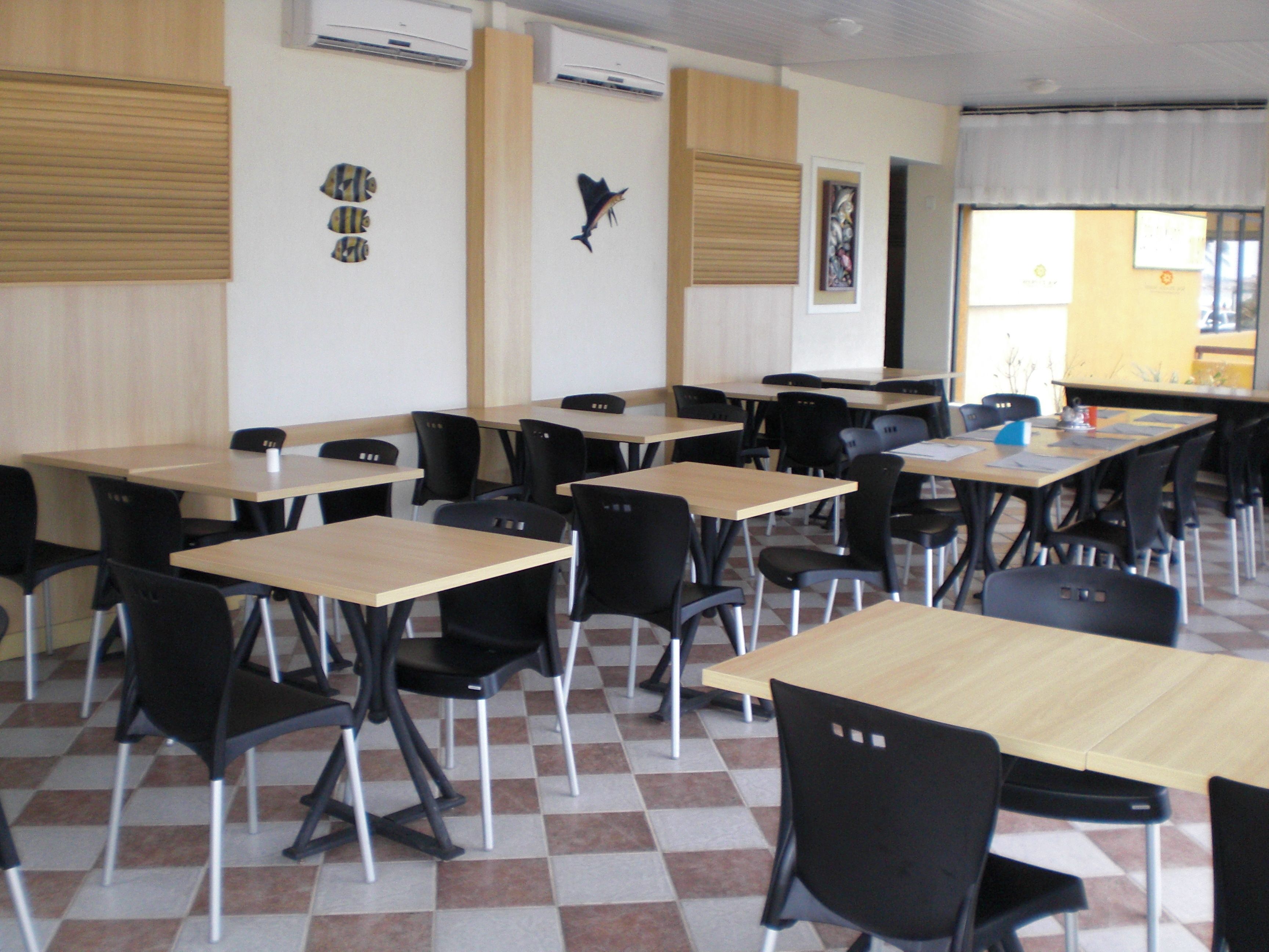 A classroom with black chairs and wooden desks, arranged in rows.