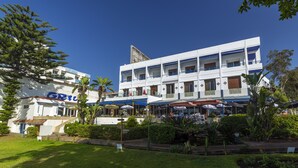 Un hotel de varios pisos con zonas de estar al aire libre y un jardín bien cuidado.