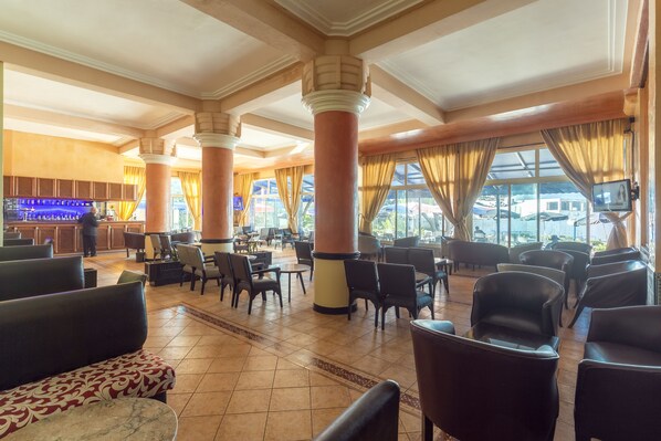 A spacious lobby with high ceilings, large columns, and a bar area.