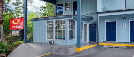 A blue building with a sign for EconoLodge, a covered outdoor area, and a blue door.