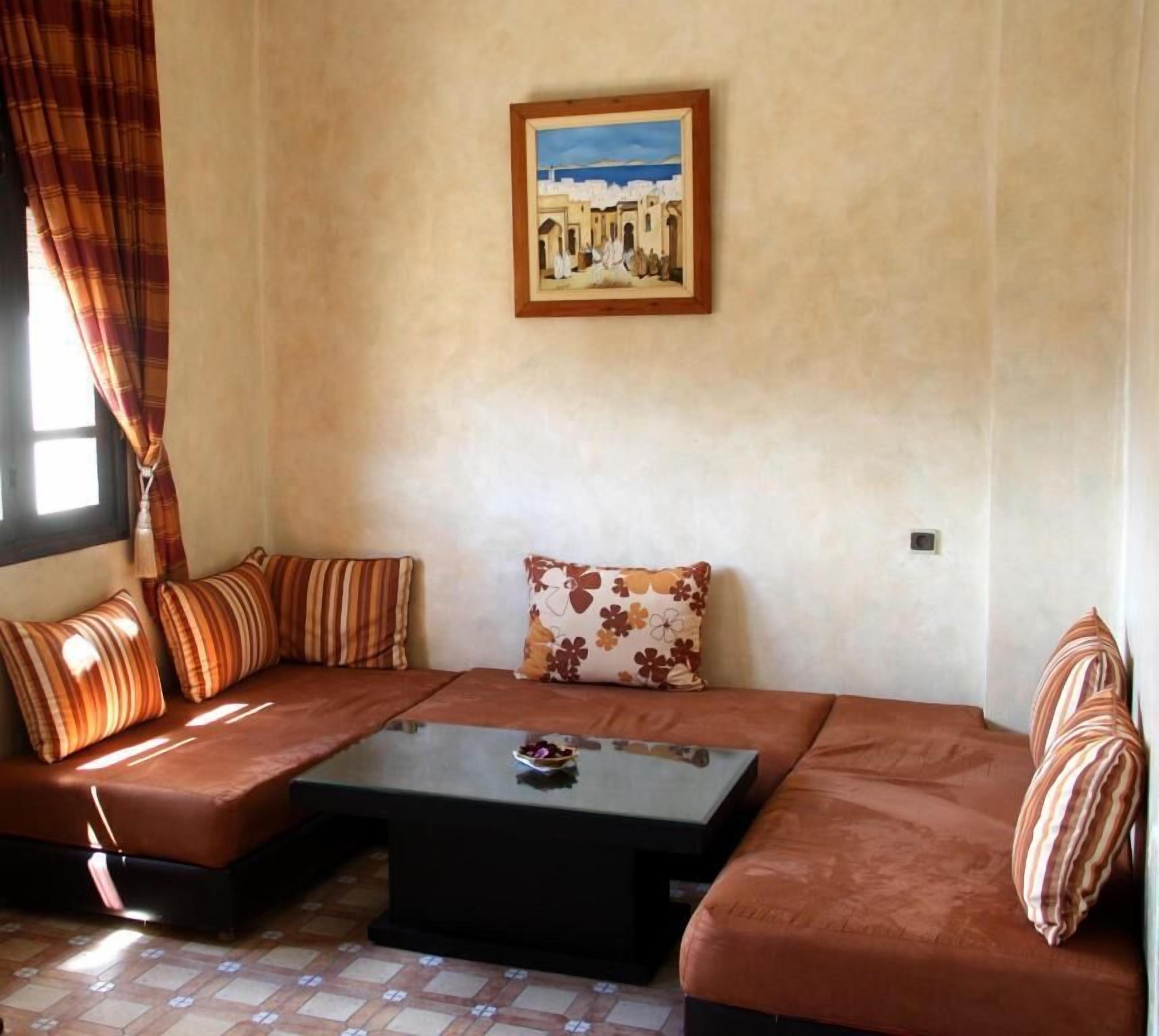 Un salon comprenant un canapé, une table basse et un tableau accroché au mur.
