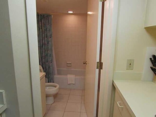 Un baño estrecho con inodoro, bañera y cortina de ducha.