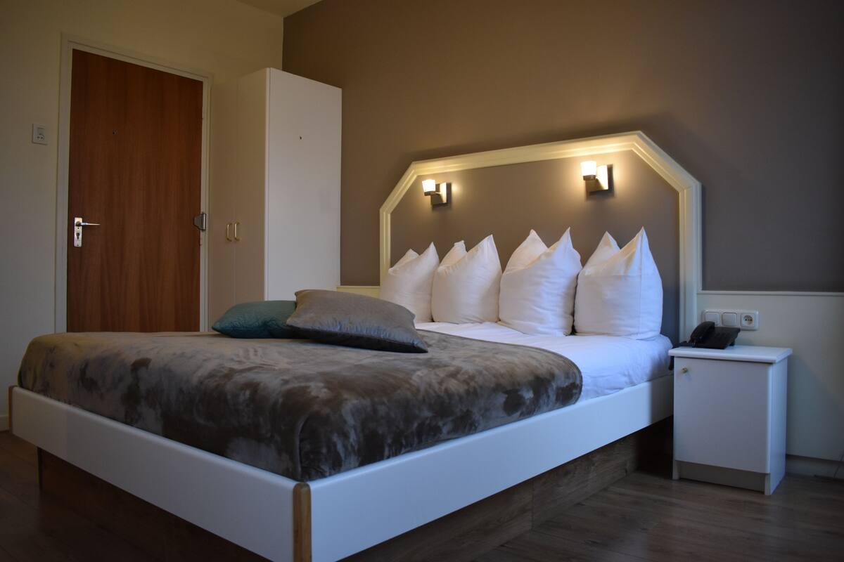 Un dormitorio con cama, mesita de noche y armario.