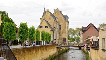 A historic building with a stone facade, a bridge, and a narrow waterway.