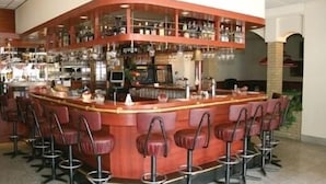A bar area with multiple stools and a counter. - Hotel 2000 (Valkenburg aan de Geul)