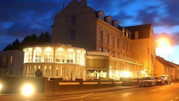 A large building with a prominent corner structure, a main entrance, and a parking area. - Hotel 2000 (Valkenburg aan de Geul)