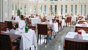 A spacious dining area with multiple tables and chairs, large windows, and a clean, well-lit interior. - Hotel 2000 (Valkenburg aan de Geul)