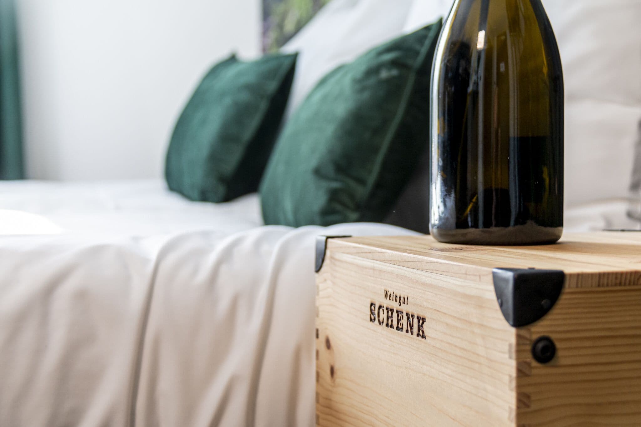A wooden box labeled "Weingut SCHENK" with a wine bottle on top.