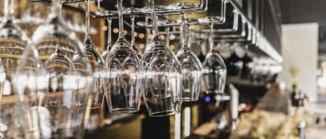 A bar area with multiple hanging wine glasses and a bar counter.