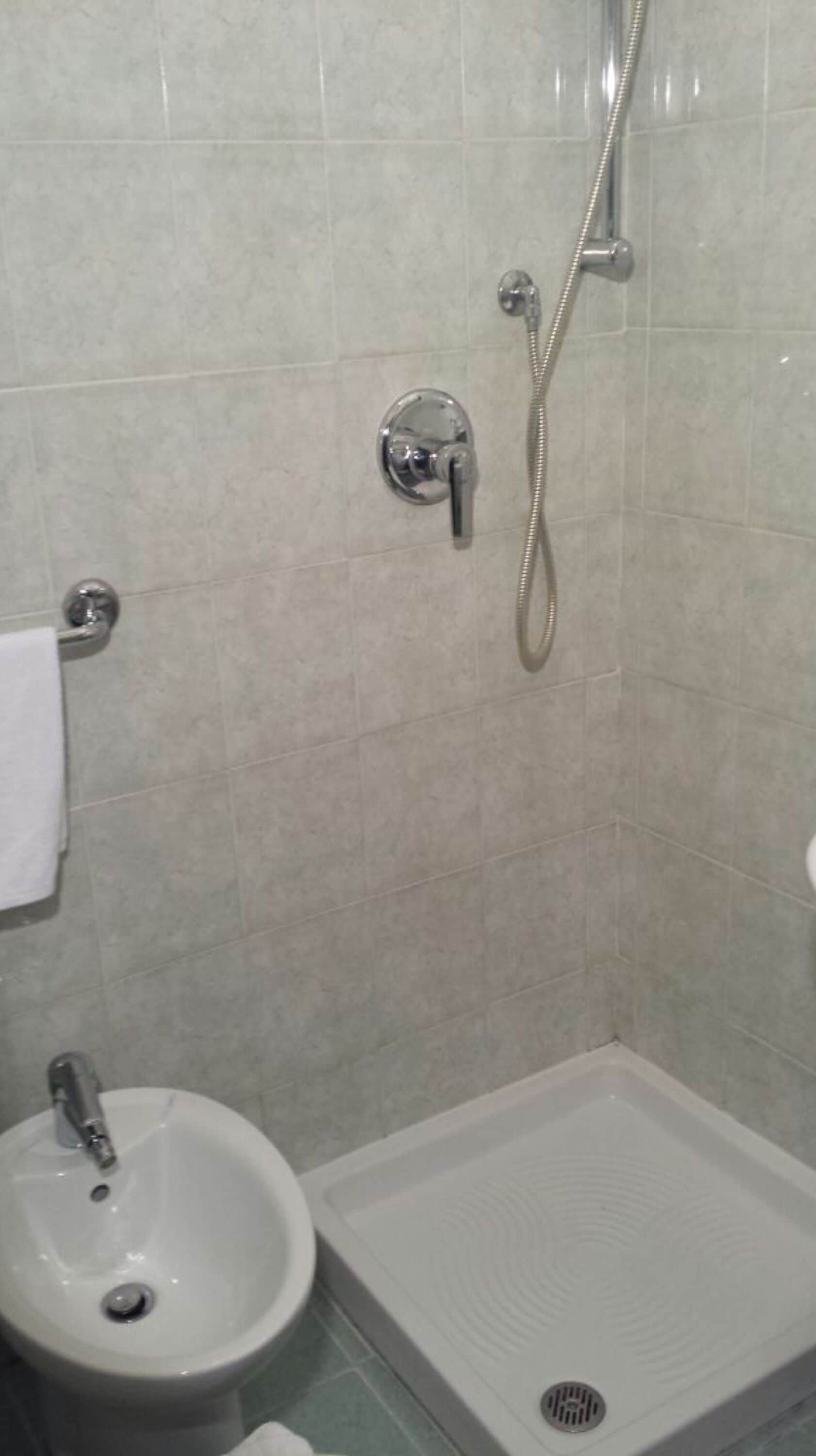 Un bagno con doccia, lavandino e WC.