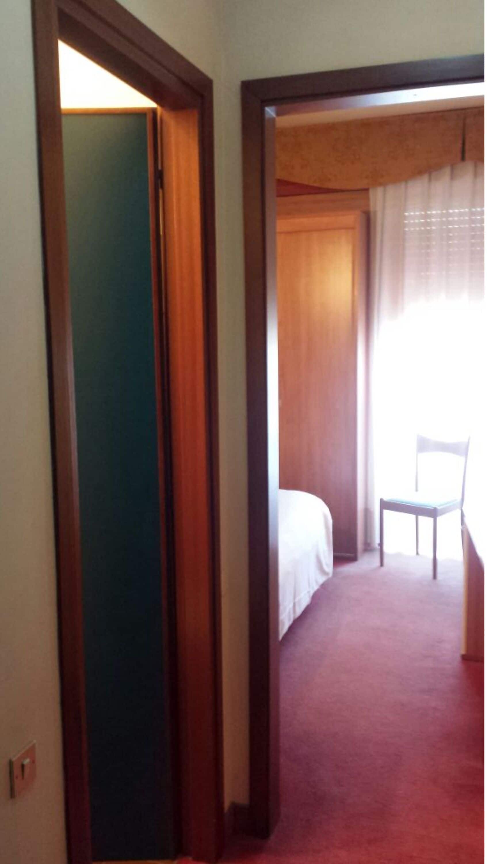 A hotel room with a bed, a chair, and a desk.