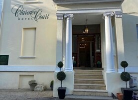 The entrance of Clarence Court Hotel with a classic facade, columns, and a welcoming staircase.