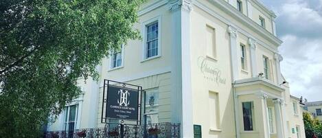 A two-story building with a sign for the Clarence Court Hotel.