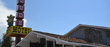 A motel with a distinctive sign spelling "DUDE" and a yellow "MOTEL" sign.